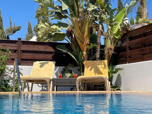 - deux chaises et une table à côté de la piscine dans l'établissement Amazing Villa with a private pool, à Protaras