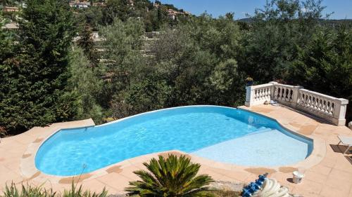 - une vue sur la grande piscine bleue dans l'établissement Appartement en Rez de Villa Beausite, à Mandelieu-la-Napoule