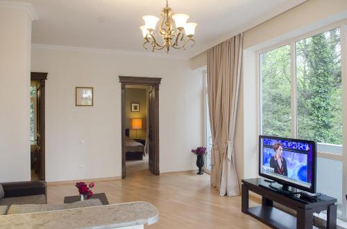 sala de estar con TV de pantalla plana y sofá en TiflisLux Apartment en Tiflis