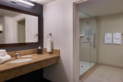 een badkamer met een wastafel en een douche bij Courtyard by Marriott Calgary Airport in Calgary