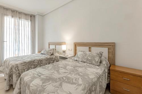 um quarto com 2 camas e uma cómoda e uma janela em Cozy Holiday Home 2 Bed 2 Bath Balcon Los Gigantes em Puerto de Santiago