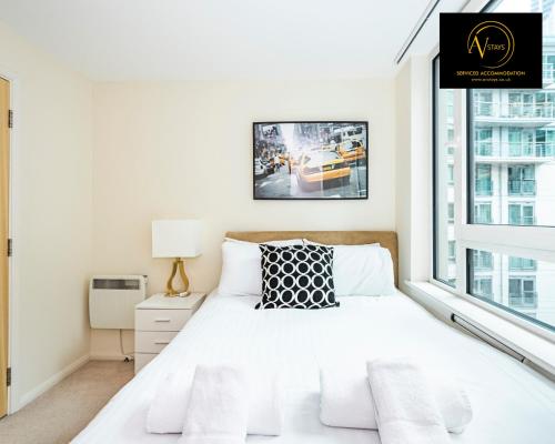 ein weißes Schlafzimmer mit einem Bett und einem Fenster in der Unterkunft 2 Bedroom Apartment by AV Stays Short Lets & Serviced Accommodation in London