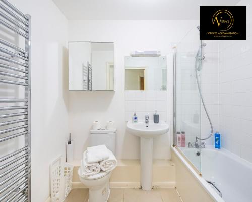 La salle de bains blanche est pourvue de toilettes et d'un lavabo. dans l'établissement 2 Bedroom Apartment by AV Stays Short Lets & Serviced Accommodation, à Londres