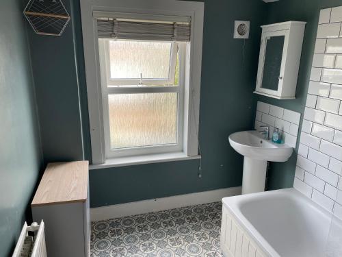 La salle de bains est pourvue d'un lavabo, de toilettes et d'une fenêtre. dans l'établissement 2BD Victorian Terrace House Ramsgate, à Ramsgate