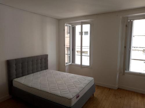 a bedroom with a bed and two windows at Studio 27 m2 Hyper centre in Château-Thierry