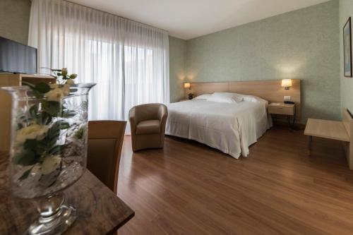 Pokój hotelowy z łóżkiem i krzesłem w obiekcie Hotel Donatello Imola w mieście Imola