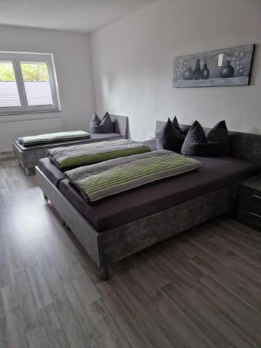two large beds in a room with wooden floors at Gelis Ferienwohnung in Aichstetten