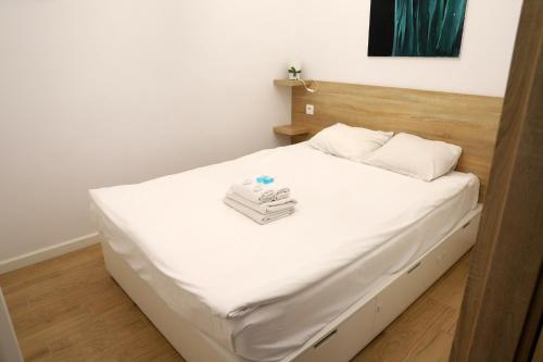 1 dormitorio con cama blanca y cabecero de madera en Urocze i ciche mieszkanie w spokojnej okolicy en Cracovia