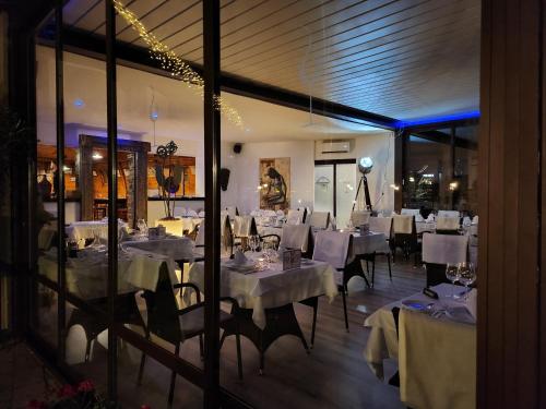 uma sala de jantar com mesas e cadeiras brancas em Arany Szarvas Fogadó és Captain Drakes Pub em Gyor