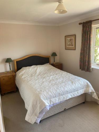 a bedroom with a large bed and a window at Goodwood Rooms in Charlton