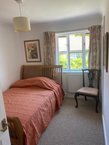 a bedroom with a bed and a window and a chair at Goodwood Rooms in Charlton