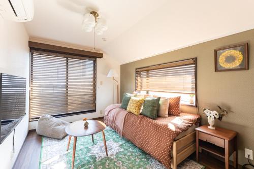 a bedroom with a bed and a table and a window at LiveGRACE Hotel Shibuya 渋谷西新宿 in Tokyo