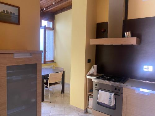 una piccola cucina con piano cottura e tavolo di Asti - La casa di ringhiera ad Asti