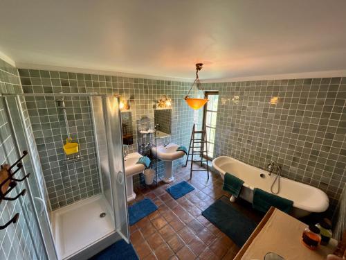 La salle de bains est pourvue de 2 lavabos, d'une baignoire et d'une douche. dans l'établissement Le Mas Saint Jacques, au Pontet