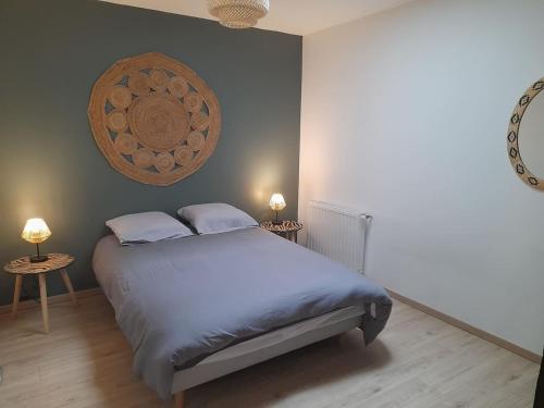 een slaapkamer met een bed met 2 tafels en 2 lampen bij Logement de 100m2 avec terrasse in Wardrecques