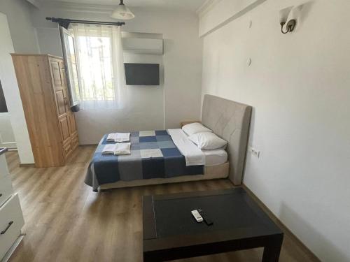 a small bedroom with a bed and a table at Tugay Hotel in Fethiye