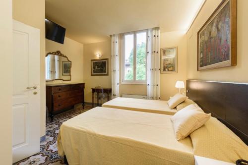 フィレンツェにあるB&B Casa Rossaのベッドルーム1室(ベッド2台、窓付)