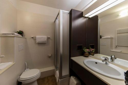 a bathroom with a toilet and a sink and a shower at Hotel Donatello Imola in Imola