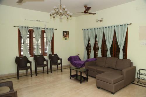 sala de estar con sofá y sillas en The Nest Lovely 3BHK and 1BHK Villa, en Chennai