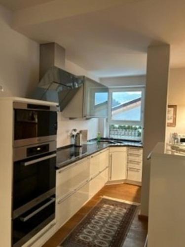cocina con electrodomésticos de acero inoxidable y ventana grande en Grossbergblick en Filzmoos