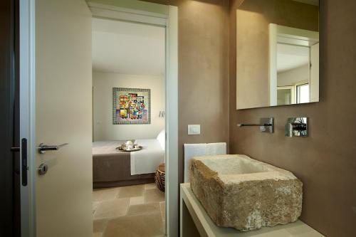 un bagno con vasca e una camera con letto di HOUSE OF RODOGALLO ad Alezio