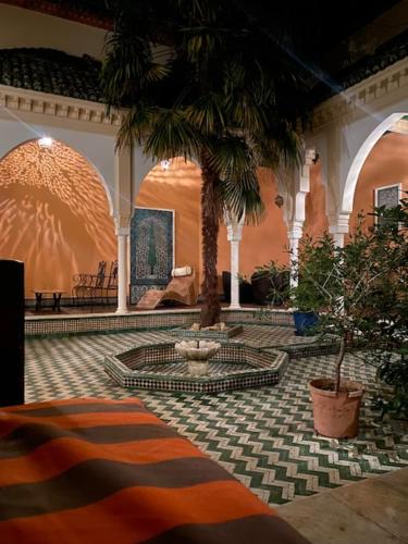 un hall avec un palmier dans un bâtiment dans l'établissement Magnifique Riad avec patio extérieur, à Vichy