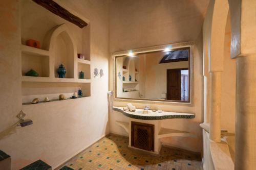 La salle de bains est pourvue d'un lavabo et d'un miroir. dans l'établissement Riad l'Ayel d'Essaouira, à Essaouira