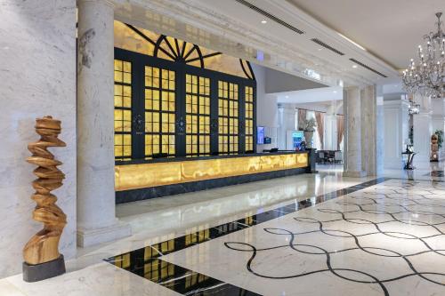 een lobby met een reflecterend zwembad en een kroonluchter bij Titanic Deluxe Golf Belek in Belek