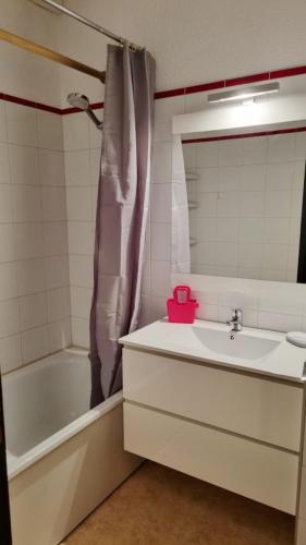 une salle de bain avec un lavabo, une baignoire et un miroir dans l'établissement Studio 4 personnes à La Rosière, à Montvalezan