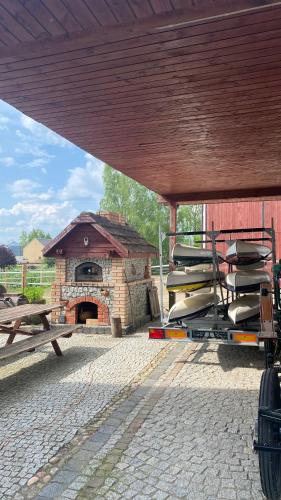 a large stone oven with a table and a building at Pełnikowe Zacisze in Bobolice