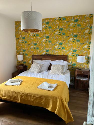 1 dormitorio con 1 cama con pared amarilla en Le CASTELOU d'IDA, en Saint-Julien-Gaulène