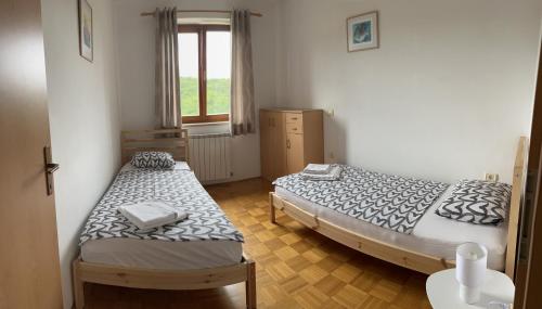 2 łóżka pojedyncze w pokoju z oknem w obiekcie Casa Monte Calvo w mieście Izola