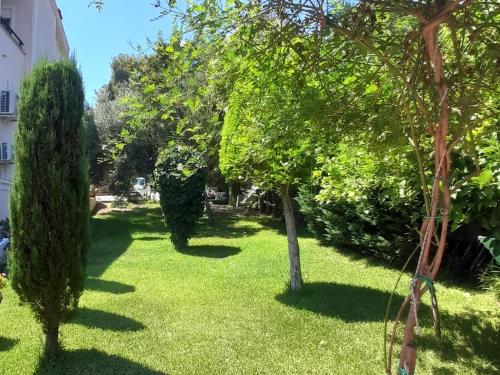 a garden with trees and grass and a building at Villa Aroma in Polykhrono