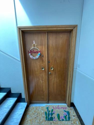 a wooden door with a crown on it next to stairs at La Maisonette apartment in Serravalle Scrivia