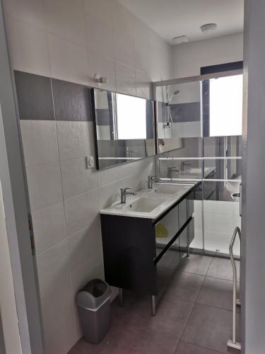 une salle de bain avec deux lavabos et un miroir dans l'établissement Maison familiale Andernos, à Andernos-les-Bains
