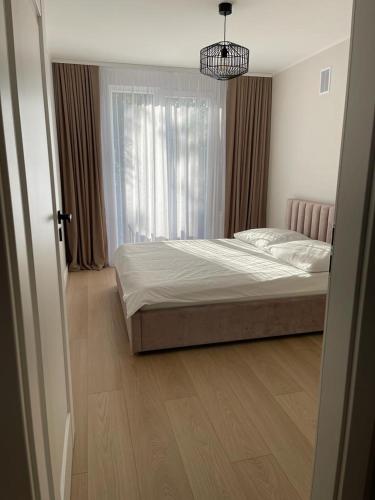 a bedroom with a bed and a window at Apartament Kasztanowa in Augustów