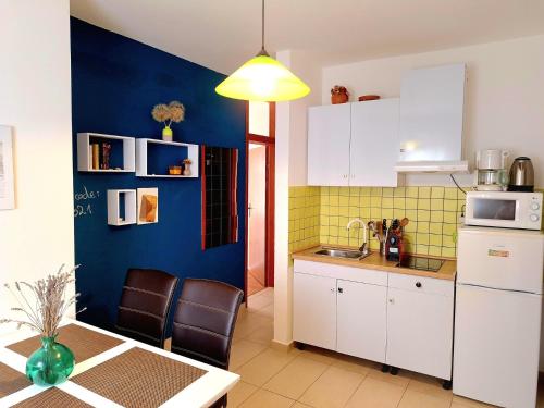 kuchnia z białymi szafkami i niebieską ścianą w obiekcie Apartment Matea - 20m from the beach w mieście Cesarica