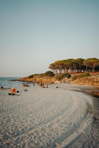 a group of people on a sandy beach at Villa Alba Sul Mare in Budoni