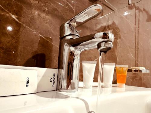 纳兰恩Kunhar Hotel RiverSide Block的浴室水槽配有水龙头和2个玻璃杯
