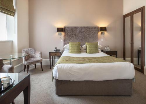 a hotel room with a large bed and a chair at Barton Hall Hotel & Spa in Kettering