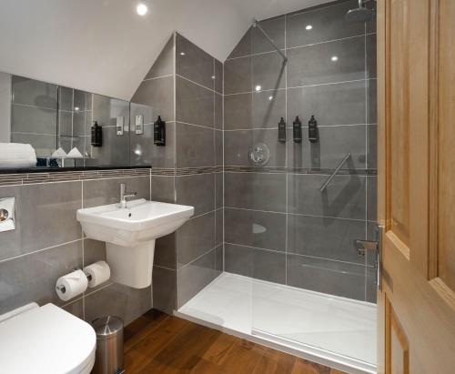 a bathroom with a shower and a toilet and a sink at Barton Hall Hotel & Spa in Kettering