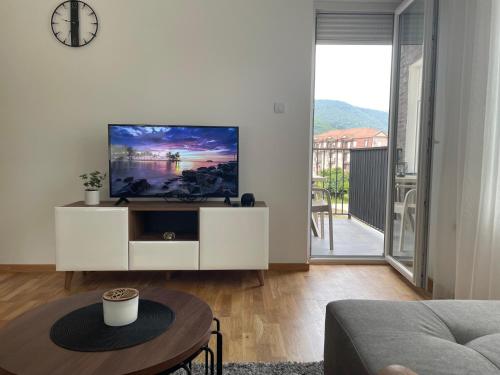 a living room with a tv on a white cabinet at Apartman Dolce Vita Sokobanja in Soko Banja