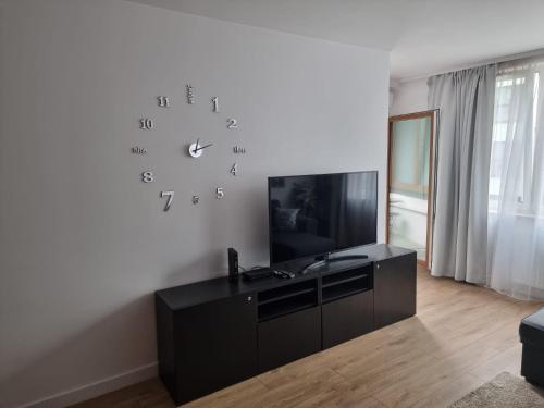 a living room with a clock on a wall at Apartament Near Sky Tower Free Parking for 2 cars in Wrocław