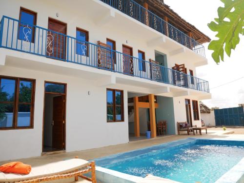 a villa with a swimming pool and a house at Sabali Lodge, Zanzibar in Jambiani