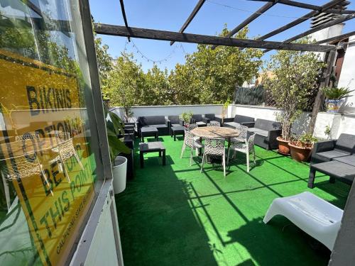 a patio with green grass and a table and chairs at The Spot Central Hostel in Seville