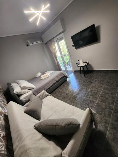 un soggiorno con 2 letti e una TV a schermo piatto di Small luxury apartment ad Anávissos