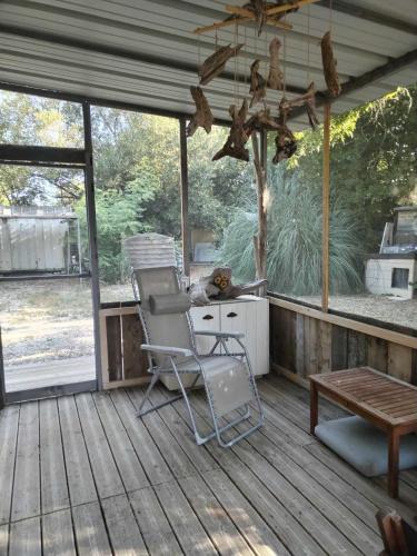 une terrasse avec une chaise et un banc dans l'établissement Ancienne Gare, à Arles