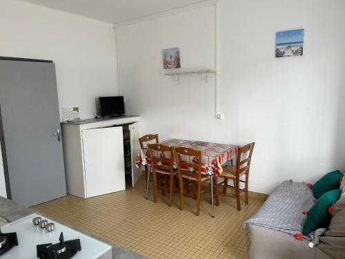 une cuisine avec une table et des chaises dans une pièce dans l'établissement La plaisance 1, à Notre-Dame-de-Monts