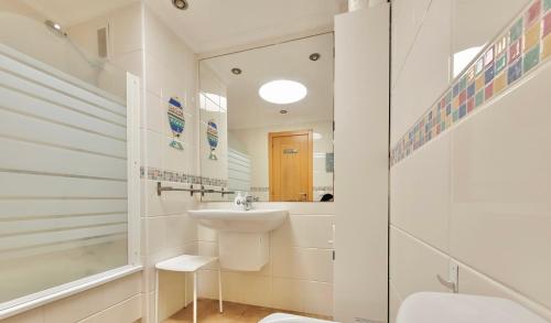 a bathroom with a sink and a toilet and a mirror at Sunny Home La Tejita in Granadilla de Abona