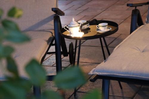 a table with two cups on it next to two chairs at Garden Villa in Štanjel